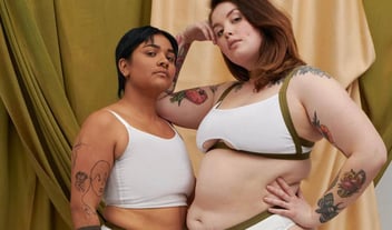 Two trans people modeling Origami Customs garments