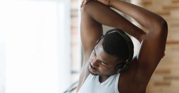A man stretching his arm above his head