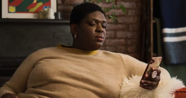 A non-binary trans woman texting on their phone