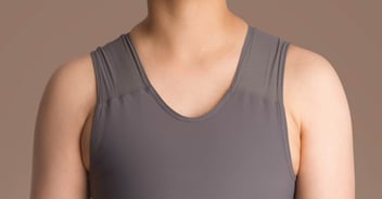 Close-up shot of a grey chest binder on a person's torso