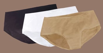 Black, white, and tan femme shapewear garments in a stack