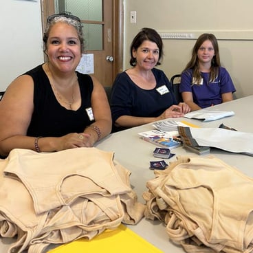 Staff and volunteers volunteer to package binders