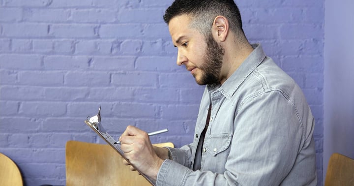 Trans masculine person completing paperwork in doctor's office