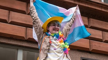 Young person raising a trans flag