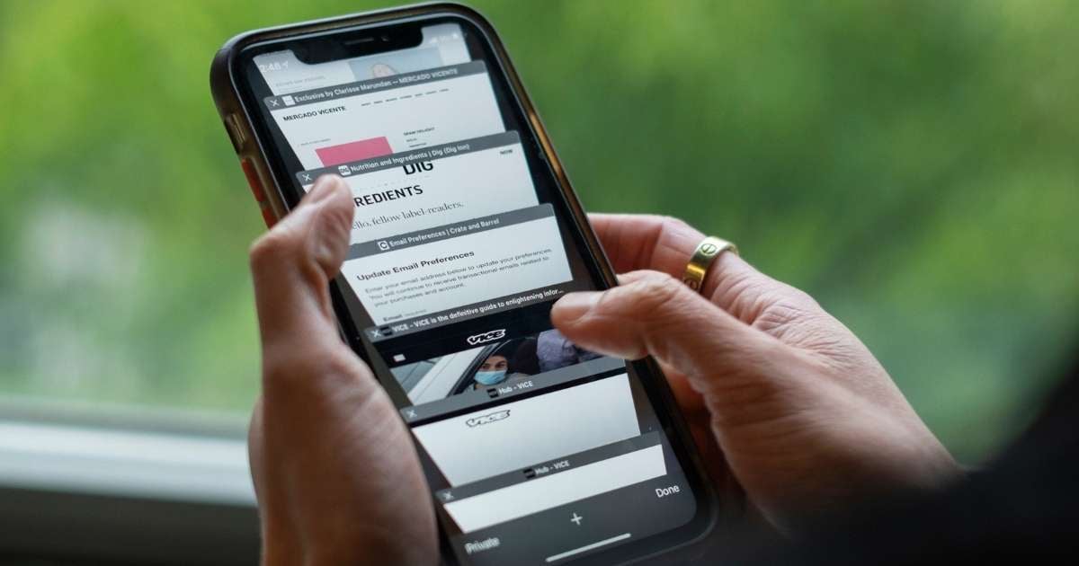 Hands browsing tabs on cell phone browser