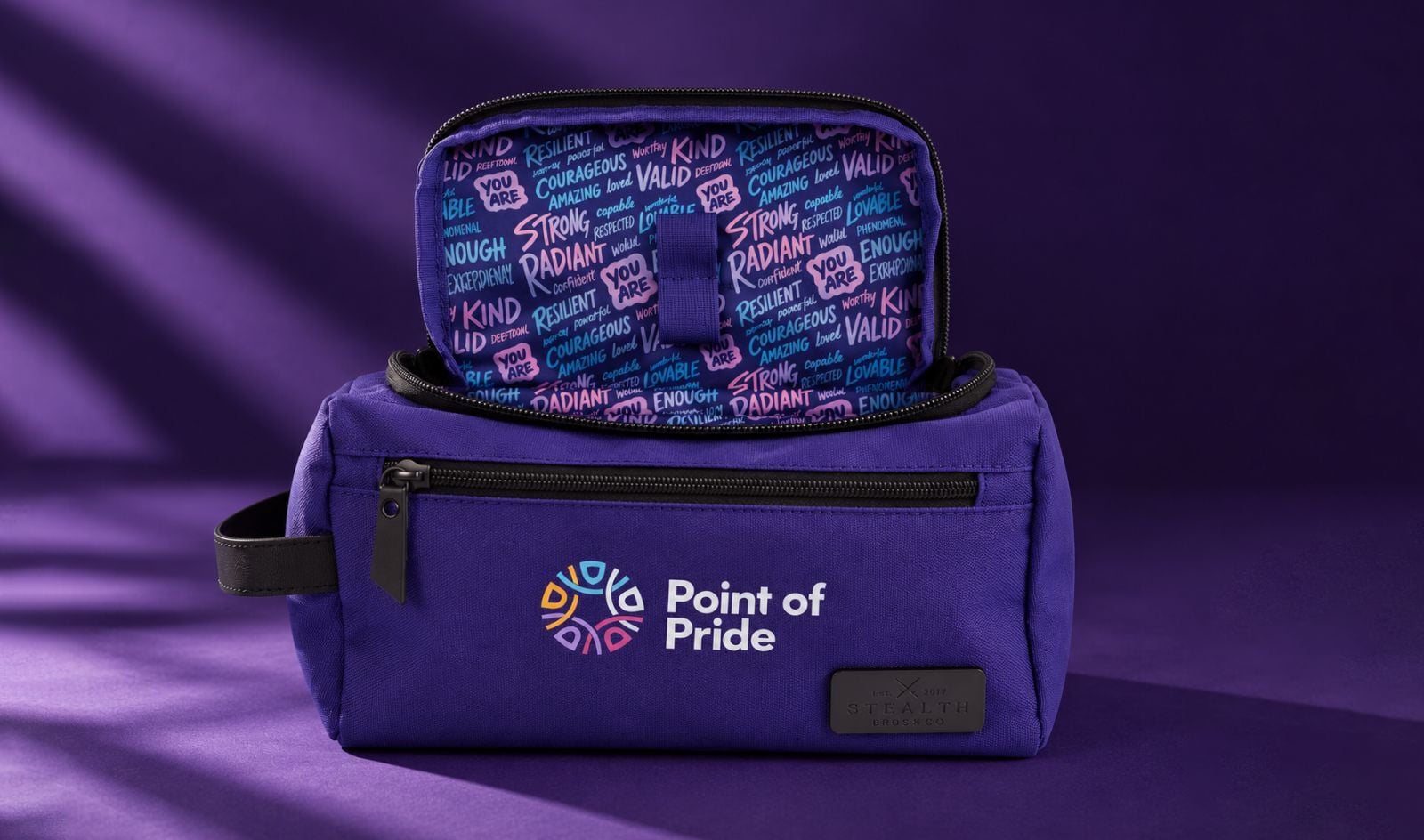 Stealth Bros x Point of Pride purple dopp kit in front of a purple backdrop