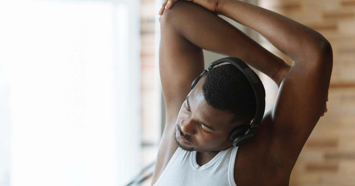 A man stretching his arm above his head