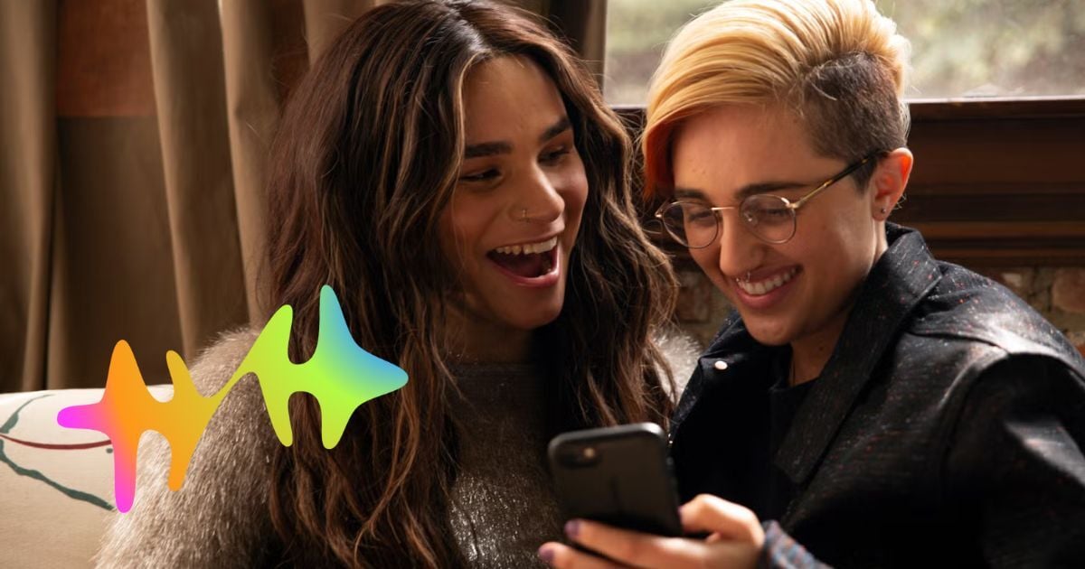 Happy trans people looking at a phone together, with the HollarHype logomark