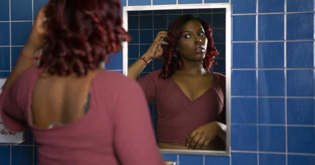 Woman looks at her reflection in the mirror