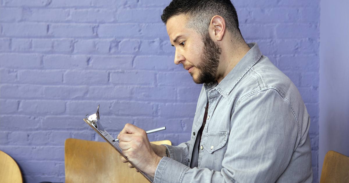 Trans masculine person completing paperwork in doctor's office
