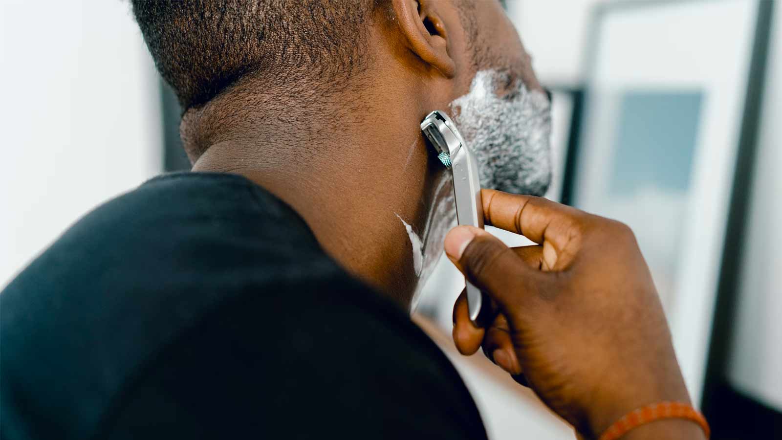 Close-up of person of color shaving their face