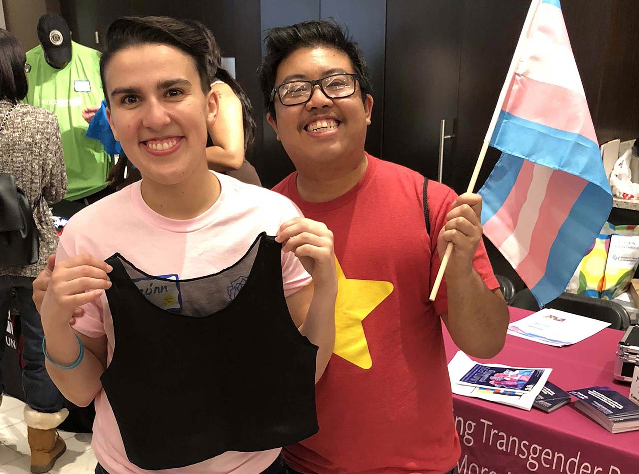 Trans youth smile with chest binder